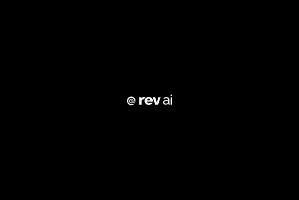 Rev AI logo in white text on a black background. Detailed: The logo for Rev AI, featuring the text "@ rev ai" in a clean, modern white font centered on a solid black background.